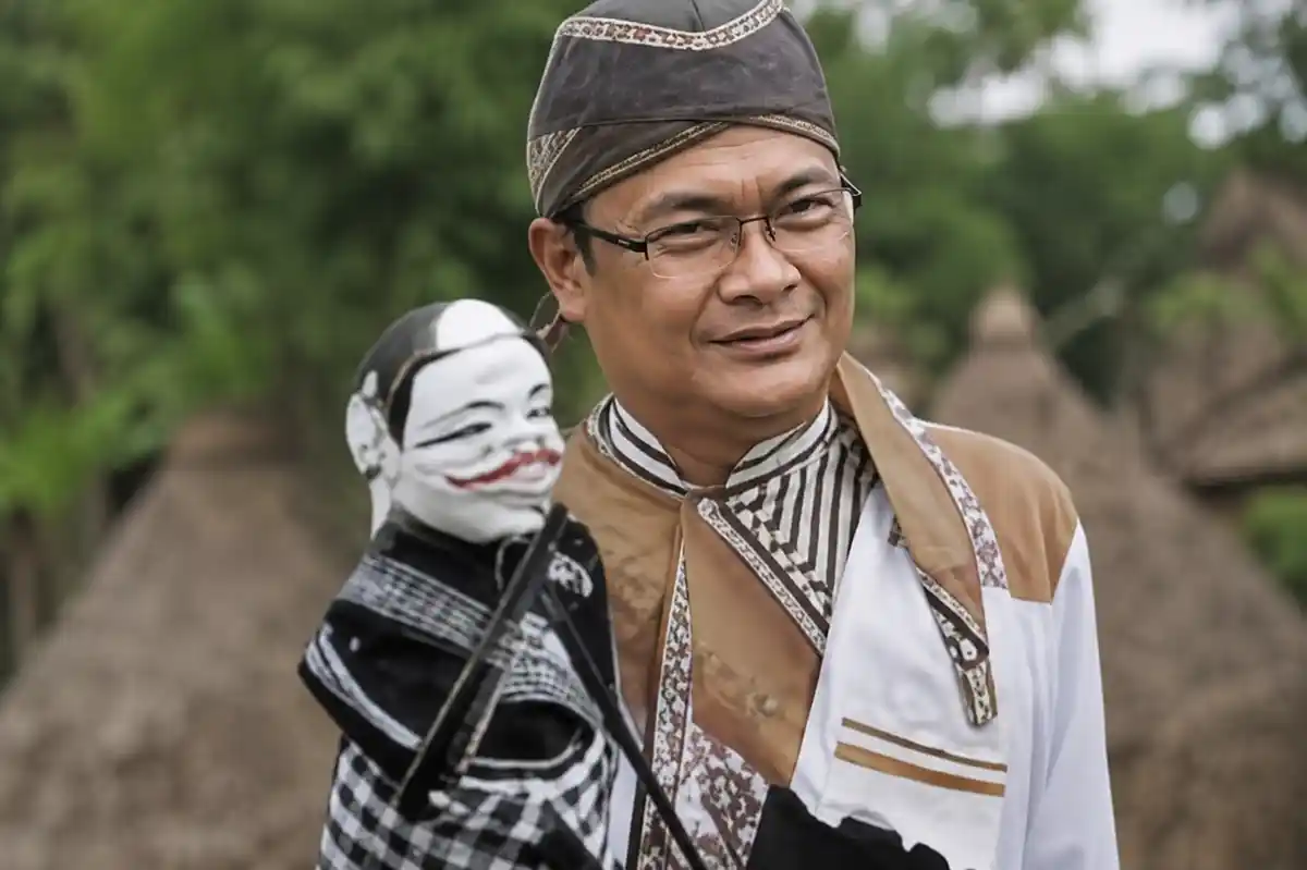 Ki Dalang Dadan Sunandar Sunarya memegang wayang golek Semar.