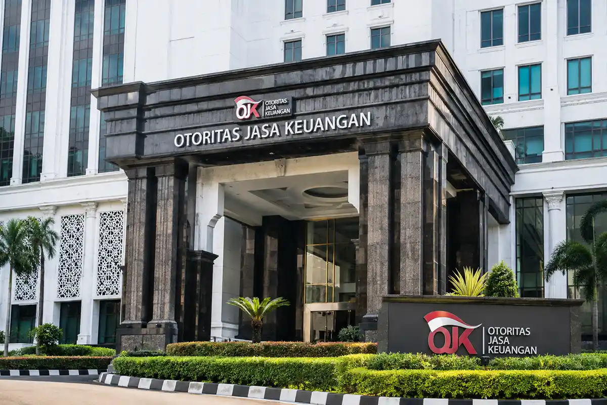 Tampak depan gedung kantor Otoritas Jasa Keuangan OJK dengan logo dan pilar megah.