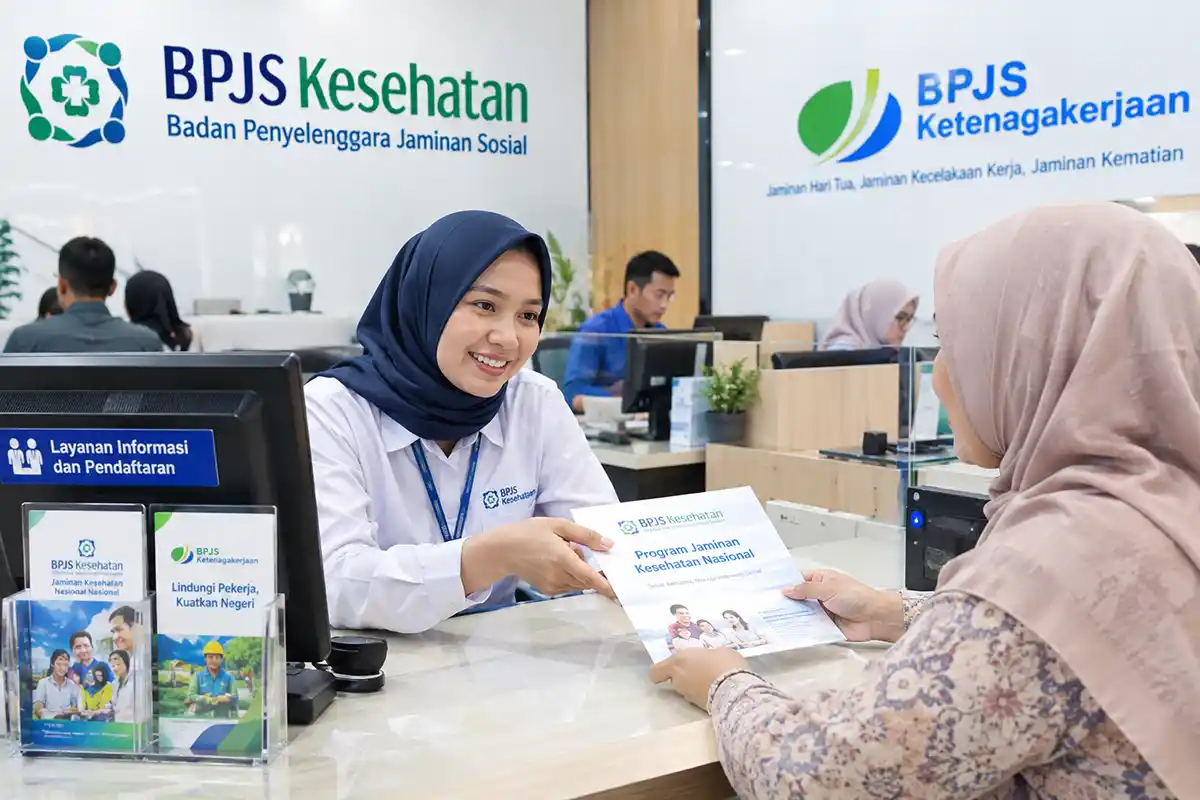 Petugas layanan informasi BPJS memberikan brosur kepada masyarakat di loket pelayanan.