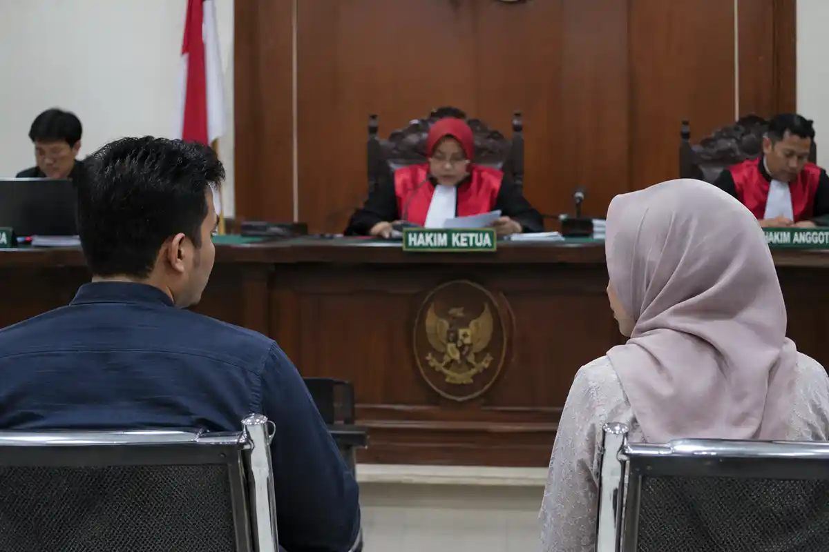 Suami dan istri sedang mengikuti proses persidangan di hadapan majelis hakim Pengadilan Agama.